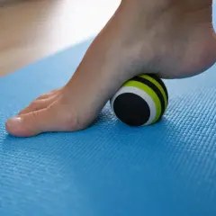 Pie con fascitis plantar rodando sobre una pelota de masaje. Descubre cómo eliminar la fascitis plantar en 72 horas con este sencillo ejercicio.