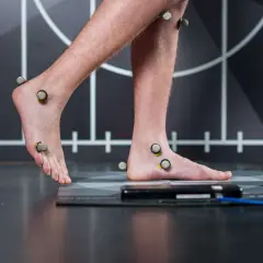 Persona con marcadores en pies y piernas para un estudio biomecánico de pisada.