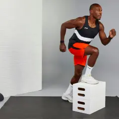 Hombre atlético subiendo un cajón blanco, demostrando resistencia muscular.