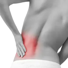 Persona con dolor en la espalda baja, señalando una zona roja que indica contractura lumbar.