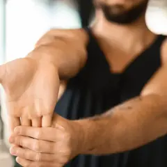Hombre realizando ejercicios de estiramiento de muñeca para aliviar la tendinitis.