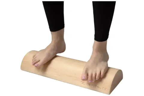 Pies descalzos sobre un tronco de madera, ideal para ejercicios de tronco hipopresivos y equilibrio.