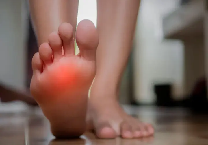 Pie con zona roja de dolor, indicando posible neuroma de Morton.