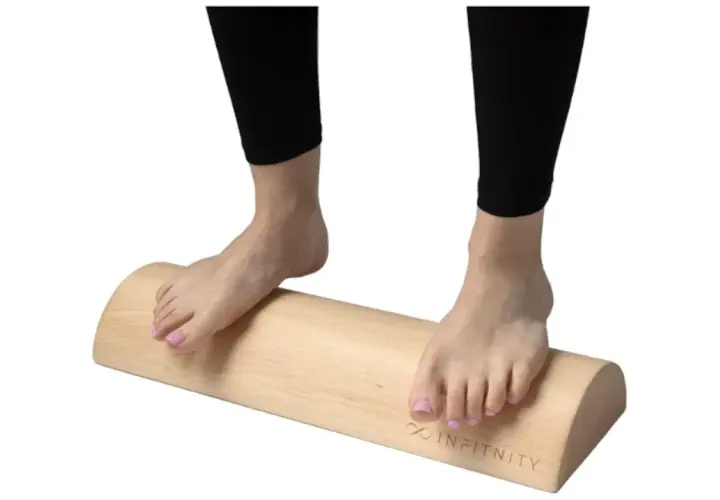 Pies descalzos sobre un tronco de madera, ideal para ejercicios de tronco hipopresivos y equilibrio.