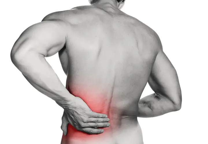 Hombre con mano en la zona lumbar, marcada en rojo, indicando dolor. ¿Cómo saber si tengo lumbago?