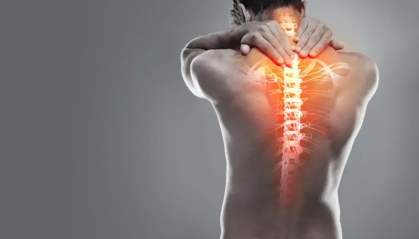 Hombre con dolor en la espalda alta, visualización de la columna vertebral con zonas de calor intenso.