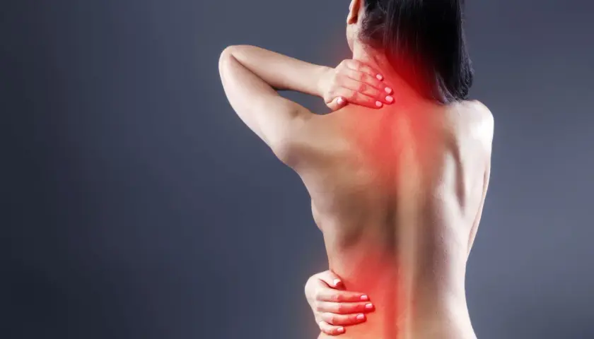Mujer con dolor de espalda, mostrando los síntomas de dorsalgia en cuello y zona lumbar, con zonas rojas de inflamación.