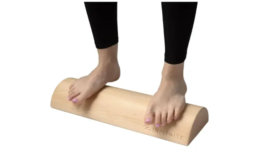 Pies descalzos sobre un tronco de madera, ideal para ejercicios de tronco hipopresivos y equilibrio.