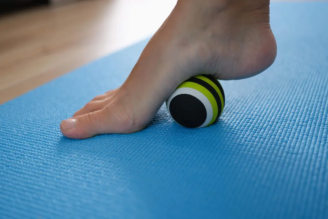 Pie con fascitis plantar rodando sobre una pelota de masaje. Descubre cómo eliminar la fascitis plantar en 72 horas con este sencillo ejercicio.