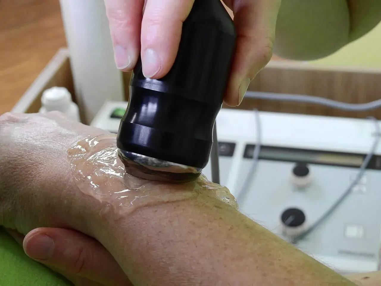 Tratamiento con ultrasonido para aliviar la tendinitis mano. Un profesional aplica gel y un dispositivo sobre la muñeca.