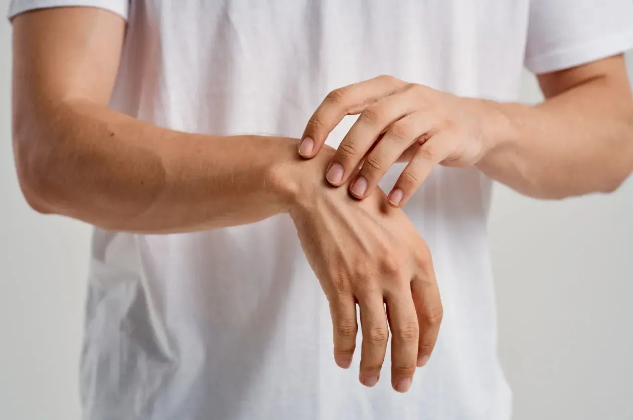 Un primer plano de un hombre tocando su muñeca, sintiendo los huesos de la mano bajo la piel.