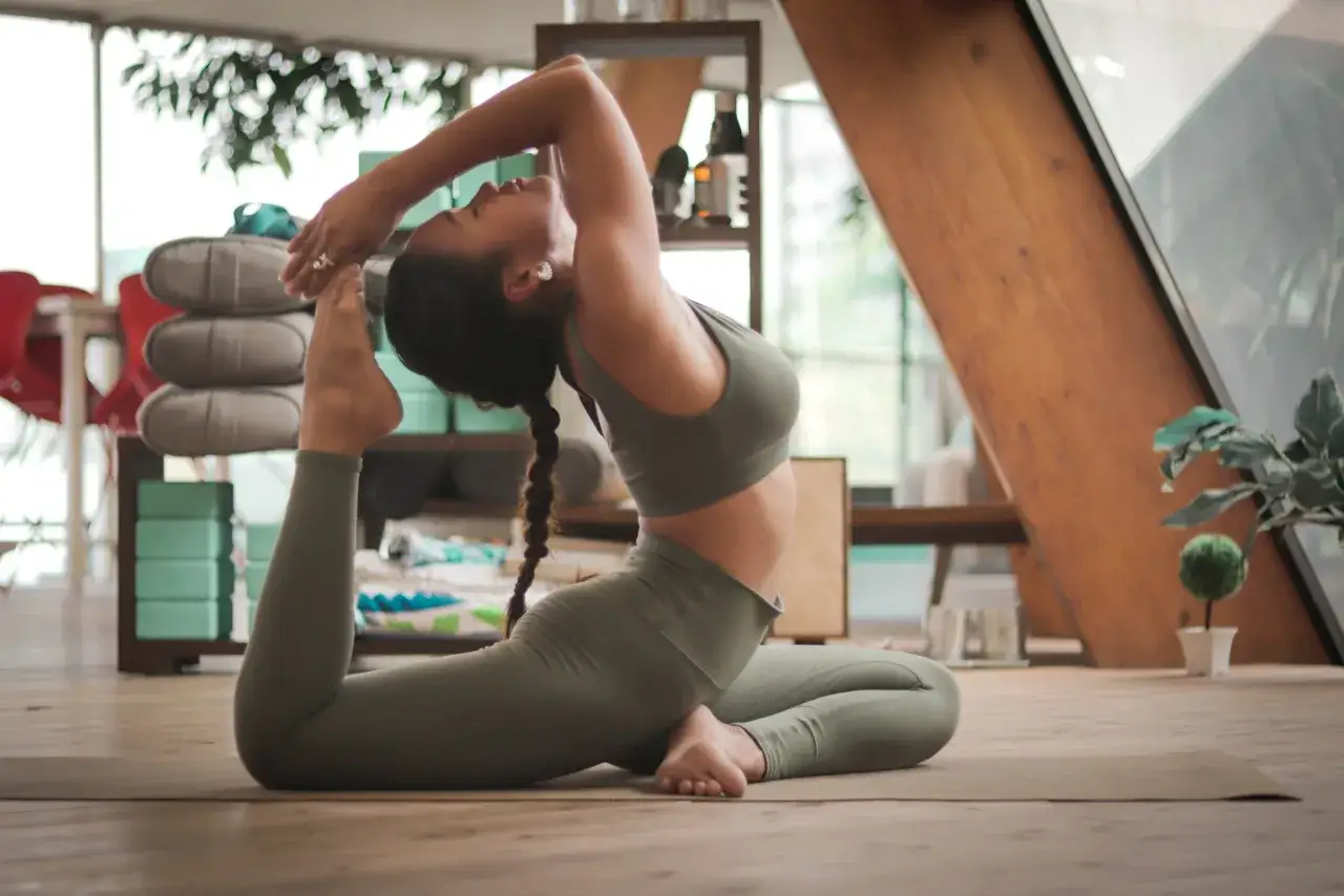 Mujer en pose de yoga, mostrando gran elasticidad muscular en su espalda y piernas.