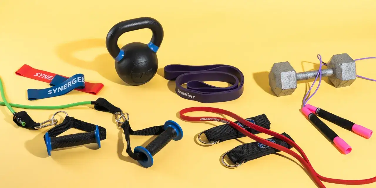 Equipo de entrenamiento: kettlebell, mancuerna, bandas de resistencia y cuerda de saltar, ideal para desarrollar resistencia muscular.